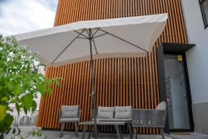 two chairs and an umbrella in front of a building at O Cantinho dos Cabrais in Inguias