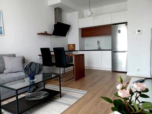ein Wohnzimmer mit einem Sofa und einem Tisch in der Unterkunft Cozy Apartment in Wilanów in Warschau