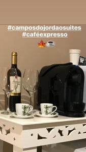 stół z 2 kieliszkami i butelką wina w obiekcie Campos do Jordão Suites w mieście Campos do Jordão