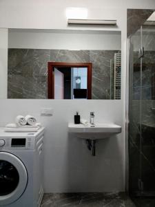 bagno con lavatrice e lavandino di Cozy Apartment in Wilanów a Varsavia