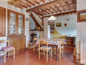 a kitchen with a table and chairs and a fireplace at Belvilla by OYO Camelia in Pescaglia