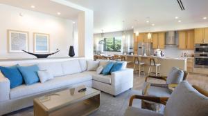 a living room with a couch and a kitchen at Maui Westside Presents - Luana Garden Villas 18C in Kaanapali