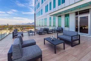 un patio con sofás y mesas en un edificio en NH Monterrey La Fe, en Monterrey