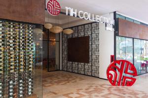 a wine store with a red chair in front of a glass door at NH Collection Merida Paseo Montejo in Mérida