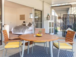 Zimmer mit einem Tisch, Stühlen und einem Bett in der Unterkunft Gartelmann Studio at Gartelmanns Wines in Lovedale