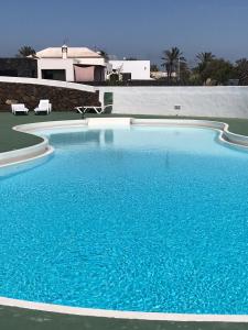 een groot blauw zwembad voor een huis bij Artsy Casa Timanfaya, Playa Blanca in Playa Blanca