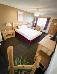 a hotel room with a bed and a desk and a chair at Fort Verde Suites in Camp Verde
