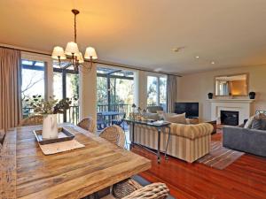 a living room with a table and a couch at Villa 3br Beaujolais Villa located within Cypress Lakes Resort in Pokolbin