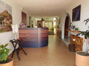 um lobby de um hotel com um balcão e plantas em Hotel Don Juan Colonial em Floridablanca