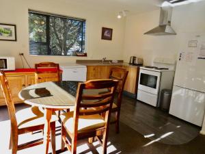 a kitchen with a table and chairs and a refrigerator at Beech Cottage - Lake Tekapo in Lake Tekapo