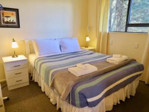 a bedroom with a bed with two towels on it at Beech Cottage - Lake Tekapo in Lake Tekapo