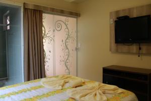 a bedroom with a bed with towels on it at Morada Recanto das Flores in Miguel Pereira