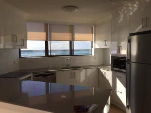 a kitchen with a sink, stove, refrigerator and dishwasher at Broadwater Shores Waterfront Apartments in Gold Coast
