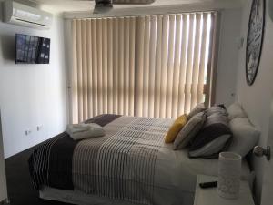 a bedroom with a bed and a window at Broadwater Shores Waterfront Apartments in Gold Coast