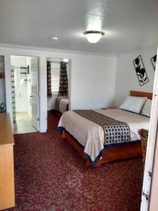 a hotel room with a bed and a bathroom at Holiday Motel Bend in Bend