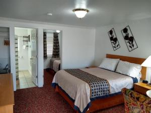 Habitación de hotel con cama y baño en Holiday Motel Bend, en Bend