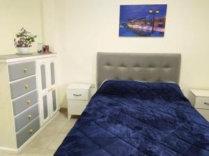 um quarto com uma cama azul e uma cómoda em Departamento Santo Tome centrico em Santo Tomé