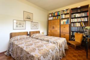 een slaapkamer met 2 bedden en boekenplanken bij Suite in Villa La Fenice in Monsummano