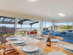 a dining room with a table with glasses and wine bottles at Antonio's Paradise in Culburra Beach