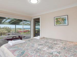 a bedroom with a large bed and a patio at Antonio's Paradise in Culburra Beach