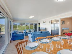a dining room with a table and a blue couch at Antonio's Paradise in Culburra Beach +18 photos