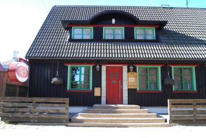uma casa preta e vermelha com uma porta vermelha em Hansalinn em Pärnu