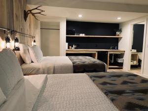um quarto de hotel com duas camas e um sofá em Outdoors Inn em Ponderay