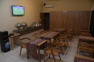 um restaurante com mesas e cadeiras e uma televisão na parede em Pasola 