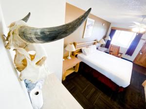 a hotel room with a bed with a whale head on the wall at Fort Verde Suites in Camp Verde