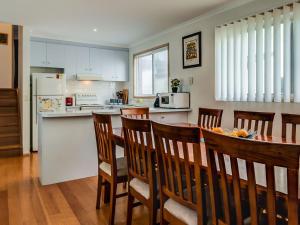 a kitchen with a table and chairs and a kitchen with a counter at Colonnades in Cape Woolamai