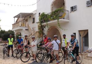 a group of people with bikes in front of a building at Masseria Salinola in Ostuni