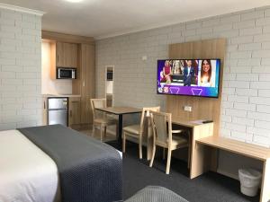 a hotel room with a kitchen and a dining room at Frewville Motor Inn in Adelaide