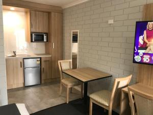 a kitchen and dining room with a table and chairs at Frewville Motor Inn in Adelaide