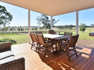 a wooden deck with a table and chairs on it at Kinloch Cottage renovated to new on Daisy Hill Vineyard in Pokolbin