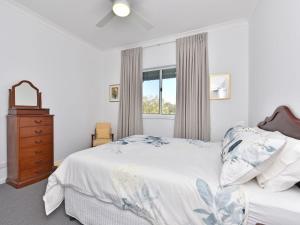 1 dormitorio con 1 cama, vestidor y ventana en Kinloch Cottage renovated to new on Daisy Hill Vineyard en Pokolbin