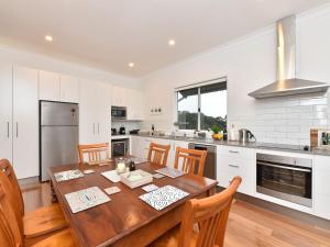 cocina grande con mesa de madera y sillas en Kinloch Cottage renovated to new on Daisy Hill Vineyard en Pokolbin