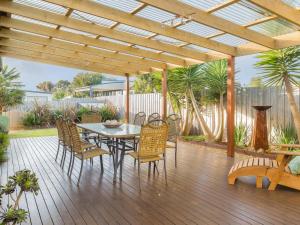 a patio with a table and chairs on a wooden deck at Island Sands in Cowes