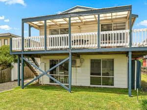 a house with a deck and a staircase at Kahakai in Surf Beach