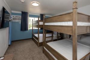 Dos literas en una habitación con paredes azules. en Hotel Pommier Indianola, en Indianola