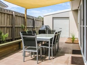 una mesa y sillas en un patio con una valla en Redwood, en Cowes