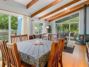 a dining room with a table and some windows at Red Rocks Villa in Cowes