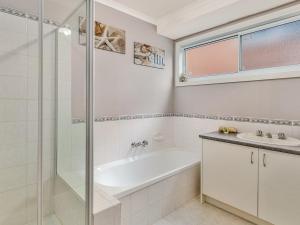 a bathroom with a shower and a tub and a sink at Red Rocks Villa in Cowes +10 photos
