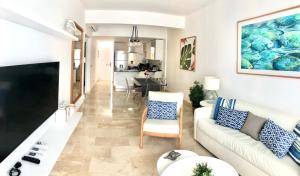a living room with a couch and a tv at Apartamento Acceso Directo a la piscina A-108, A-120, A-117 y B-136 in Punta Cana
