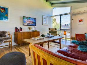 uma sala de estar com uma mesa e um sofá em Ocean Reach Retreat em Cape Woolamai