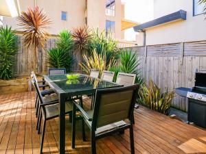 a patio with a table and chairs on a wooden deck at On Chapel in Cowes