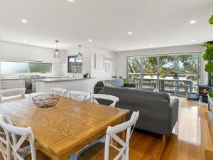 eine Küche und ein Wohnzimmer mit einem Holztisch in der Unterkunft Olive Grove in Smiths Beach