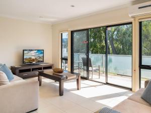a living room with a couch and a tv at Penguins by the Beach in Cowes