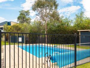 a fence around a swimming pool with a dog in it at Penguins by the Beach in Cowes