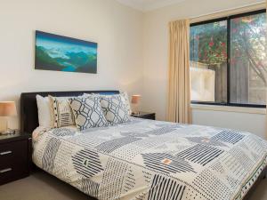 a bedroom with a bed with a large window at Penguins by the Beach in Cowes +12 photos