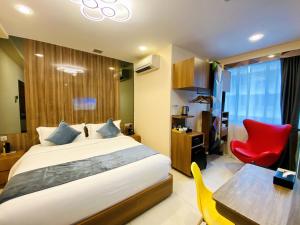 Schlafzimmer mit einem Bett, einem Schreibtisch und einem roten Stuhl in der Unterkunft five6 Hotel Splendour in Singapur